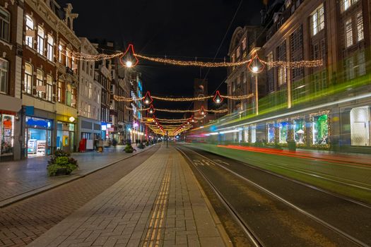 Tram driving on Damrak in christmas time in Amsterdam Netherlands