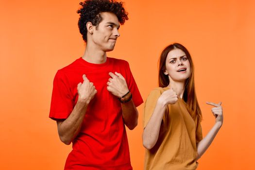 young couple fun friendship communication orange background fashion. High quality photo