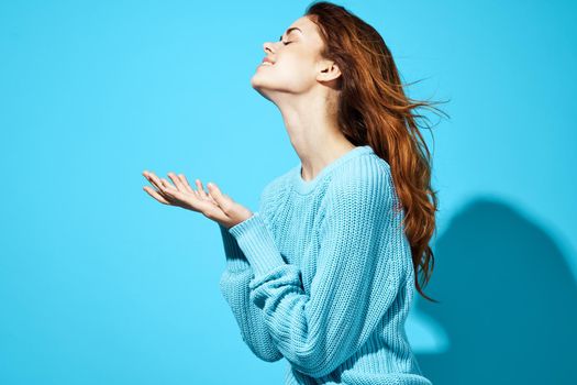 beautiful woman in a blue sweater blue background Lifestyle. High quality photo