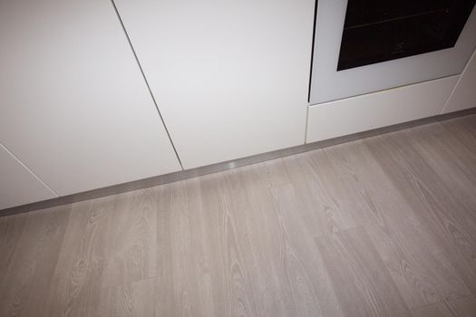 New kitchen in renovated house with laminated timber flooring.