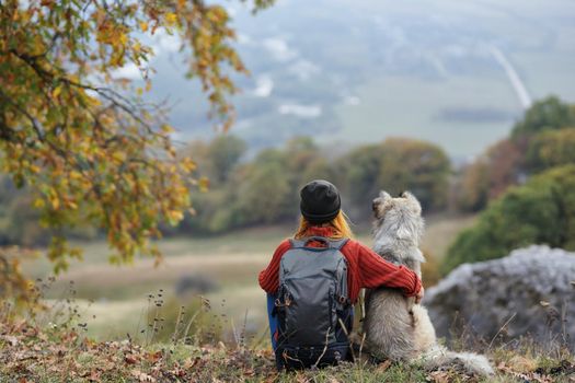 woman travels in the mountains with a dog friendship. High quality photo