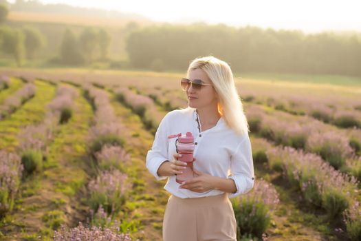 woman with bottle of water in lavender field.