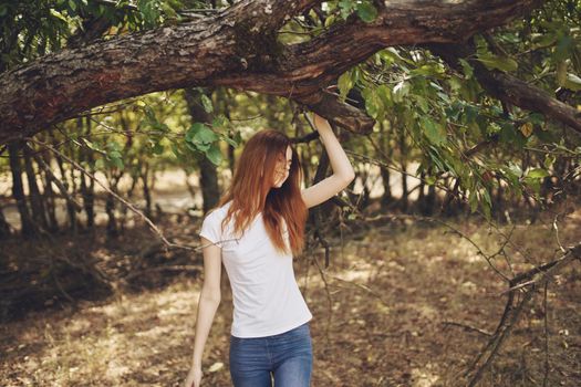 pretty woman outdoors by the tree nature Lifestyle summer. High quality photo