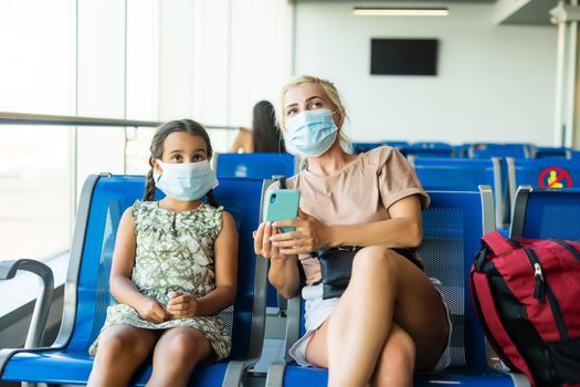 happy mother and daughter at airport travelling together.