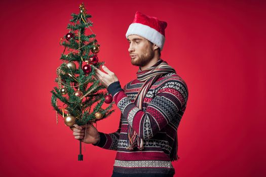 man with decorated christmas tree holiday christmas fun red background. High quality photo