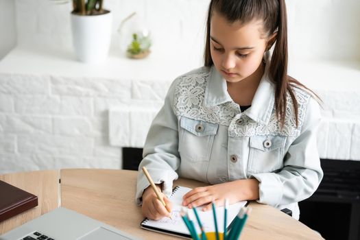 Student little school girl homework on laptop computer silver background