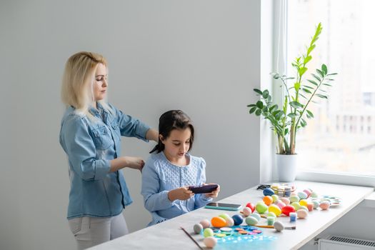 Happy family preparing for Easter. mom combing daughter.