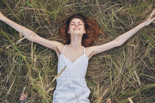 cheerful woman lies on the grass rest lifestyle nature. High quality photo