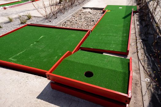 green artificial grass and rocks on miniature golf course.