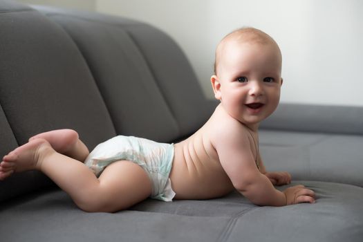 Six month boy sits on the white background.