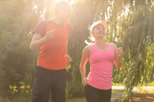 a woman and a man go in for sports in the forest.