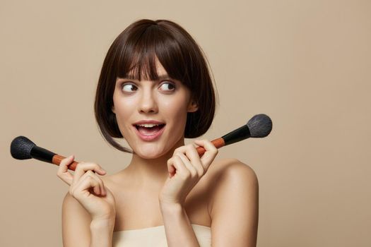 portrait woman makeup brushes in hand model makeup posing isolated background. High quality photo
