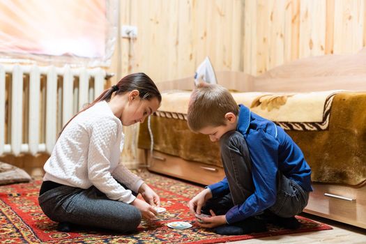 Children playing with blocks on the floor - focus on the boy's face.