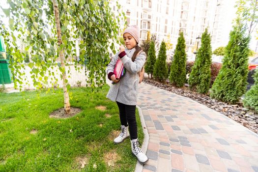 School club. Modern education. Private schooling. Teen with backpack. Stylish smiling schoolgirl. Girl little fashionable schoolgirl carry backpack school building background. Schoolgirl daily life