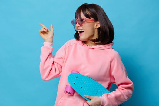 young woman teenager skateboard emotions youth style blue background. High quality photo