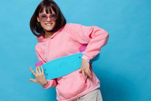 young woman in a pink sweater skateboard entertainment Lifestyle fashion. High quality photo