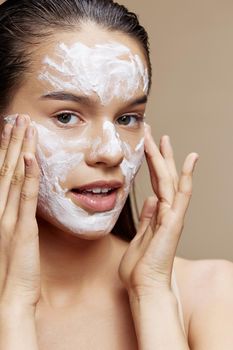 young woman face mask cream clean skin facial scrub beige background. High quality photo