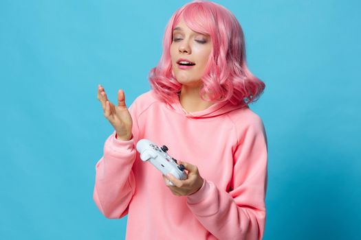 woman with a joystick in the hands of the game posing blue background. High quality photo