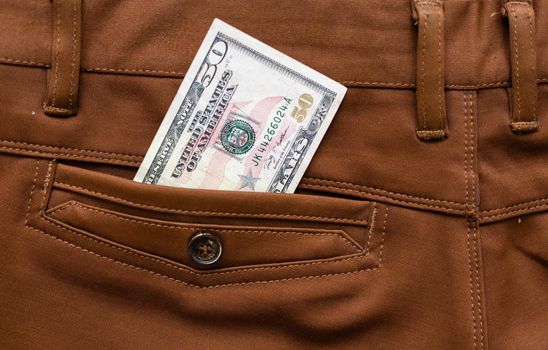 American dollar bills in jeans pocket background.