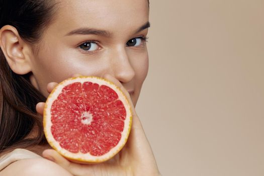 young woman grapefruit in hands smile vitamins close-up Lifestyle. High quality photo