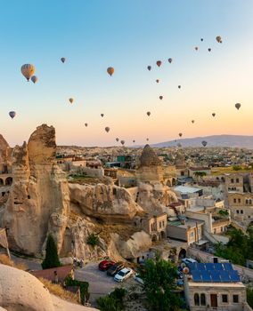 Hot air balloons over rocks in Cappadocia