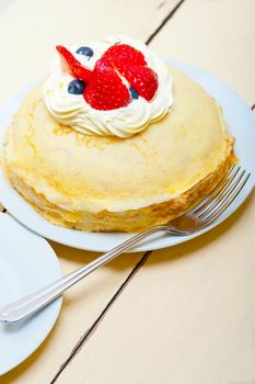 crepe pancake cake with whipped cream and strawberry on top