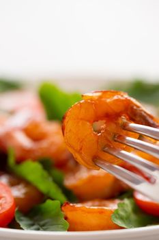 Close-up of fresh shrimp, tomato, arugula and greens salad, vertical image with copy space.