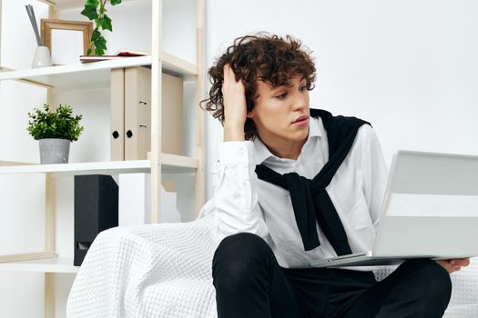 teenager sitting on the couch at the table in front of a laptop living room. High quality photo