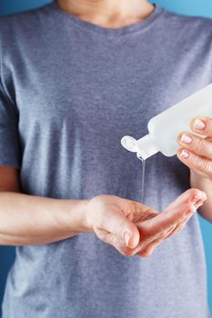 Close-up of a girl holding a Disinfectant gel in her hands. Antiseptic treatment of hands from bacteria Sanitizer. Free space, isolate.