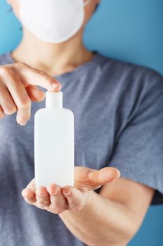 Close-up of a girl holding a Disinfectant gel in her hands. Antiseptic treatment of hands from bacteria Sanitizer. Free space, isolate.
