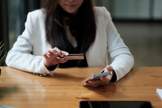 Young woman holding credit card and using smart phone for online shopping. Online payment shopping concept. copyspace banner.