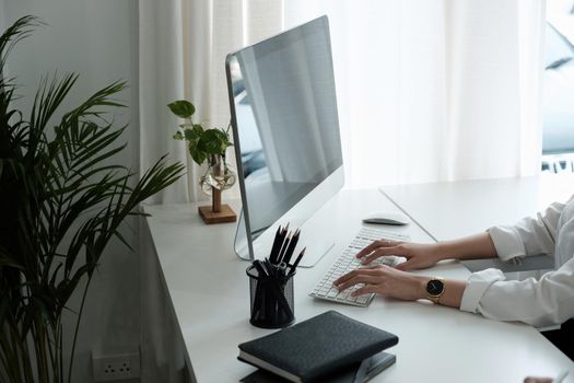 Close-up of woman hands typing on computer keyboard indoors. Businessman working in office or student browsing information.