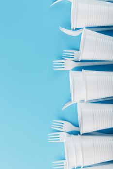 Dishes made of white plastic on a blue background. Free space. The view from the top