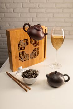 tea table with appliances and wine glasses, in which large-leaf tea is brewed