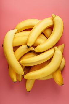 A bunch of ripe Yellow Bananas on a Pink Background. The View From The Top. Minimalistic concept. Free space