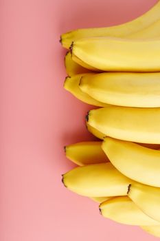 Fresh bunch of yellow bananas isolated on a pink background. Minimalistic concept. Free space