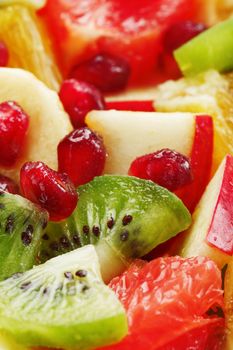 Fruit salad close-up in full screen, as a background. Slices of fresh and healthy fruits for a healthy diet.