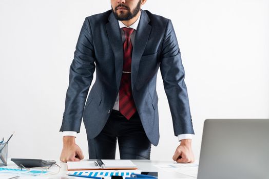 Businessman in suit and tie standing near office desk with financial charts. Meeting in conference room. Business idea presentation, analyze and strategy planning. Entrepreneurship and leadership