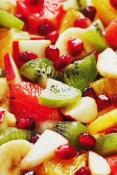 Fruit salad close-up in full screen, as a background. Slices of fresh and healthy fruits for a healthy diet.