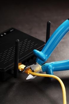 Cutting and disconnecting the network Internet connection with cutting pliers. Disabling the Wi-Fi router network. Life without internet. Disconnection for non-payment