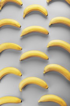Geometric pattern of yellow bananas on a gray background in the Fashionable colors of 2021. Top view. Minimal flat style. Pop art design, creative summer concept.