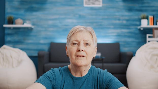 Portrait of retired person with sportswear looking at camera, preparing to do physical exercise and fitness workout. Close up of elder woman waiting to do aerobics and gymnastics.
