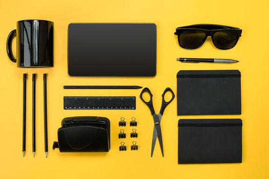 Workplace with office items and business elements on a yellow background. Concept for branding. Top view. Copy space. Still life