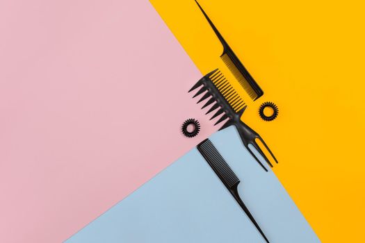 Set of combs on the color pink, yellow, blue paper background.. Top view. Copy space. Still life. Mock-up. Flat lay