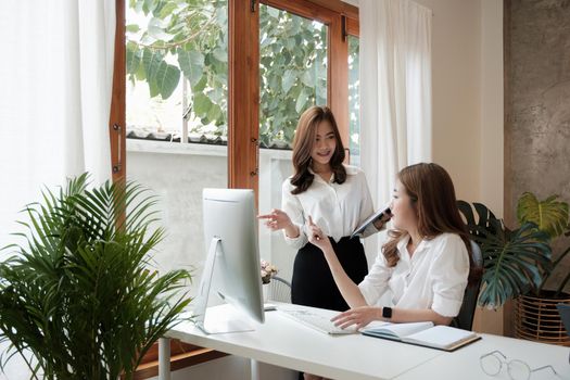 Business professionals. Group of young asian confident business people analyzing data using computer while spending time in the office.