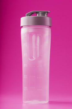 Sports smoothie bottle on pink background. Free space, minimalistic concept