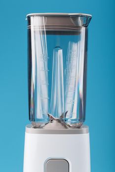Electric blender with an empty cup on a blue background. Free space, minimalistic concept