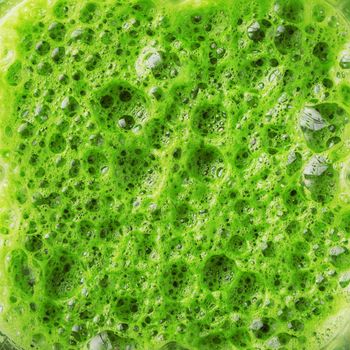 Green smoothie mixed in a blender bowl, top view. The concept of delicious and healthy food.