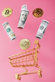 Dollar bills and itkon coins flew out of the Golden Basket on a pink background. Concept businesses, finance, trading, or stock exchange investments