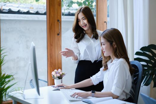 College students reading and studying and tutor together before final exam with desktop computer at home